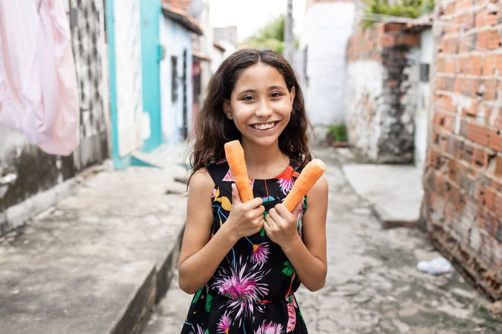 Girl standing outside holding carrots